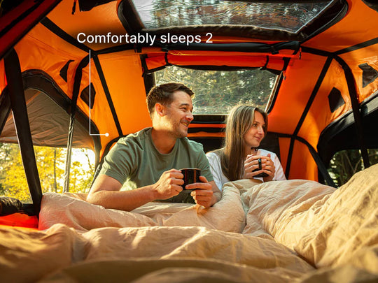 Couple using TentBox Lite roof tent at a UK campsite with car parked in nature